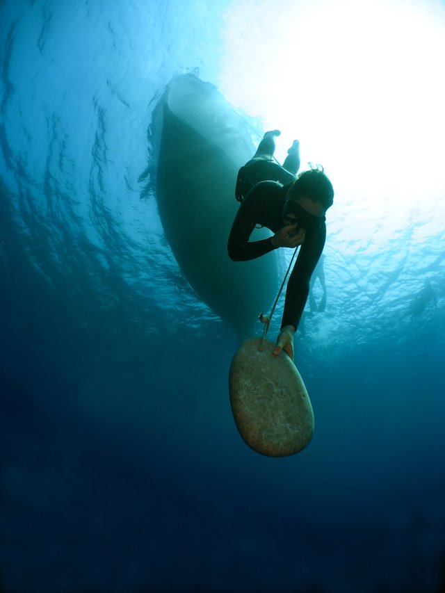 Emma Farrell freediving with a skandalopetra stone in Kalymnos, Greece